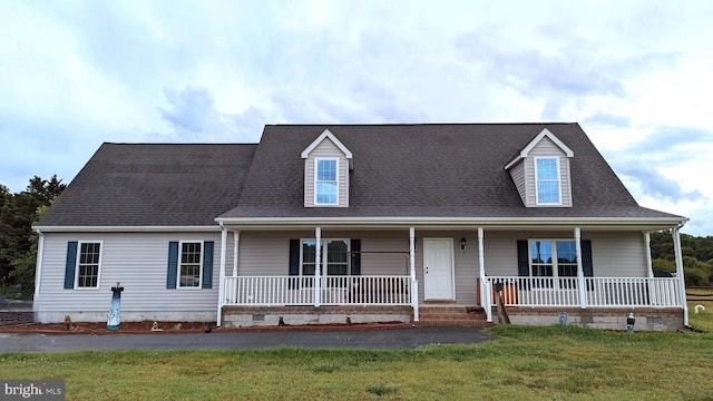 cape cod-style house featuring a front yard and covered porch