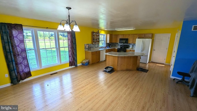 kitchen with black appliances, decorative backsplash, decorative light fixtures, a kitchen island, and a chandelier