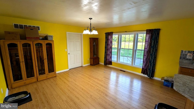 interior space featuring light hardwood / wood-style floors and an inviting chandelier