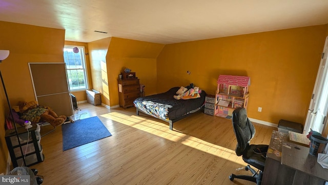 bedroom featuring vaulted ceiling and light wood-type flooring