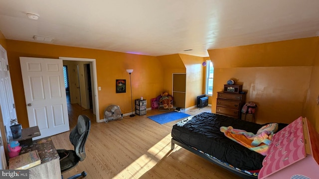 bedroom with hardwood / wood-style flooring and lofted ceiling