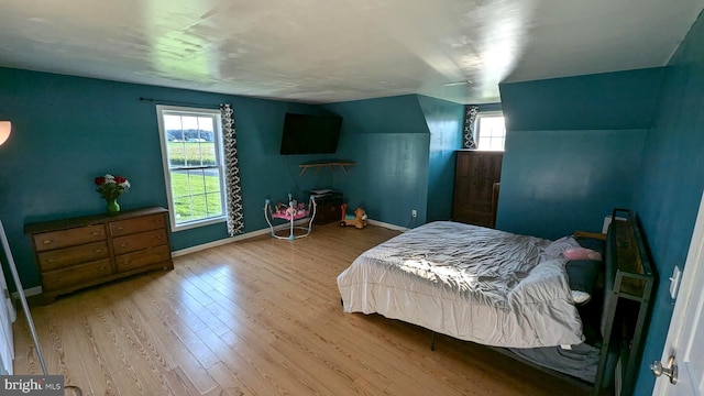 bedroom featuring light hardwood / wood-style floors and vaulted ceiling