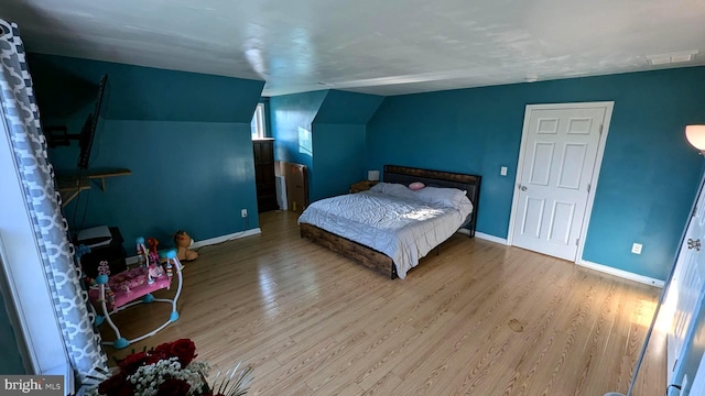 bedroom with lofted ceiling and hardwood / wood-style flooring