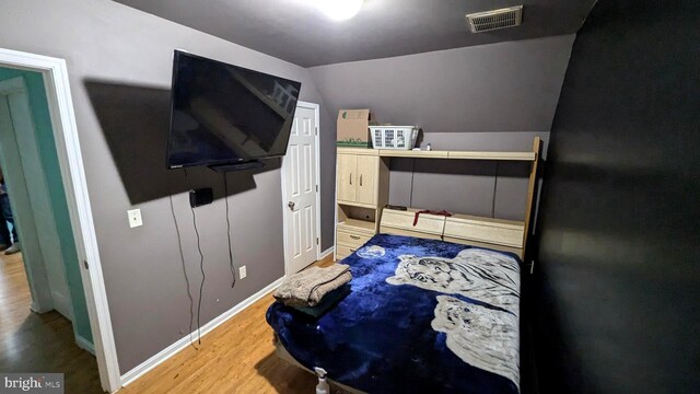 bedroom with hardwood / wood-style flooring and vaulted ceiling