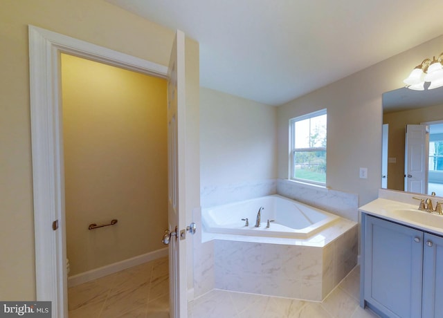 bathroom with tile patterned floors, vanity, and tiled tub