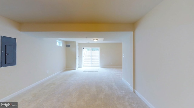 corridor with light colored carpet and electric panel