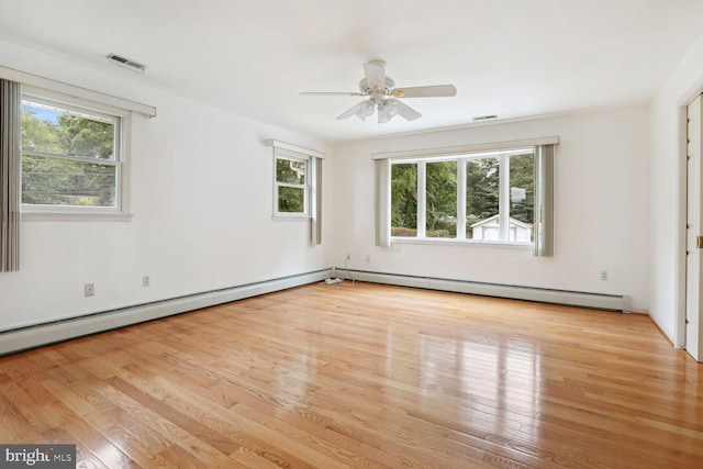 empty room with ceiling fan, a baseboard heating unit, and light wood-type flooring