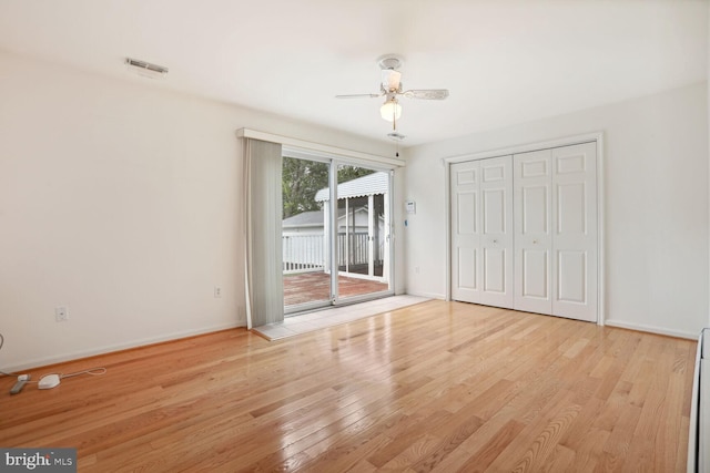 unfurnished bedroom with access to exterior, light hardwood / wood-style flooring, a closet, and ceiling fan