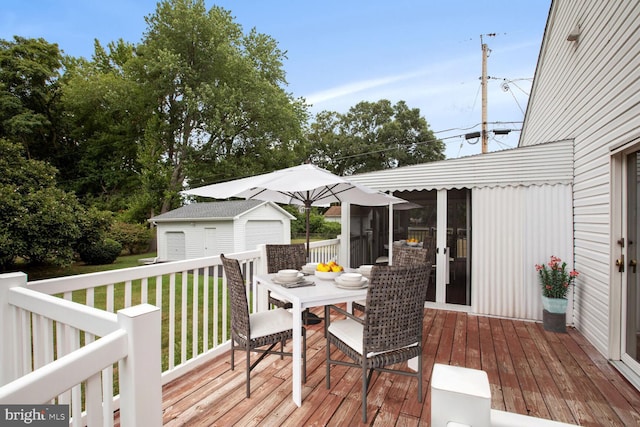 deck featuring a garage, an outdoor structure, and a yard