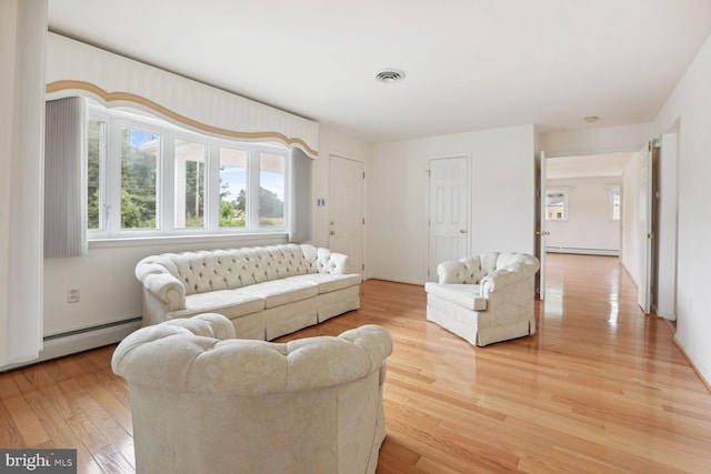 living room featuring wood-type flooring and a baseboard heating unit