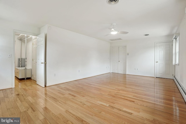 unfurnished room featuring a baseboard heating unit, light hardwood / wood-style flooring, and ceiling fan