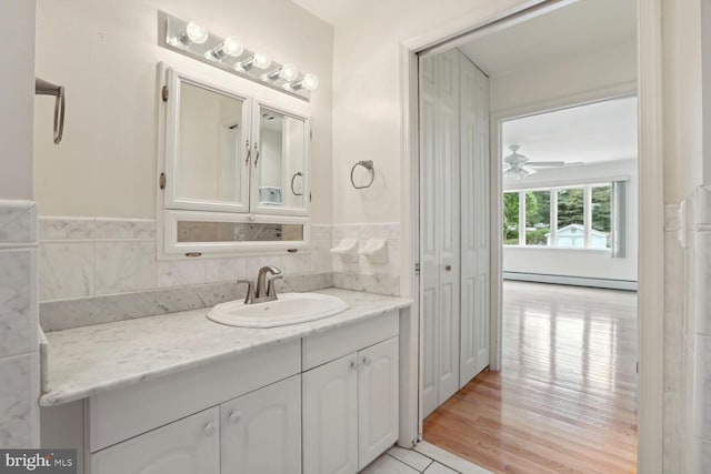 bathroom featuring ceiling fan, a baseboard radiator, vanity, and wood-type flooring