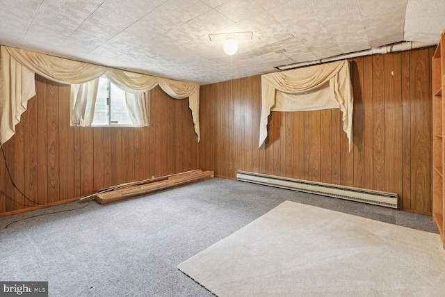 carpeted spare room with a baseboard radiator and wooden walls