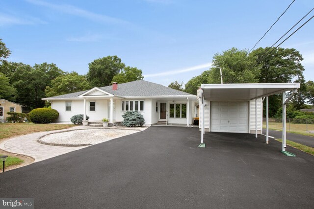 view of front of home with a garage and a carport