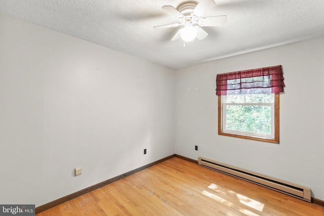 spare room featuring ceiling fan, a baseboard heating unit, a textured ceiling, and wood-type flooring