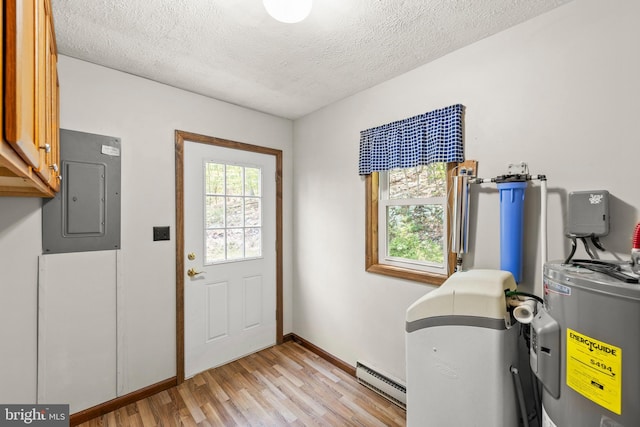 laundry area with electric water heater, a baseboard heating unit, electric panel, plenty of natural light, and cabinets