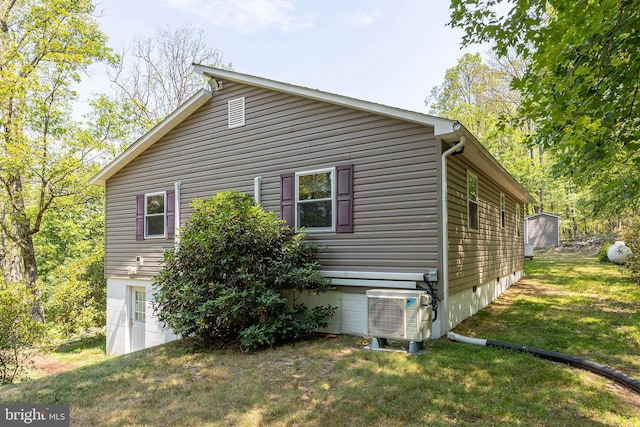 view of side of home with ac unit and a yard