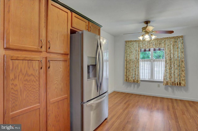 kitchen featuring stainless steel fridge, light hardwood / wood-style flooring, and ceiling fan