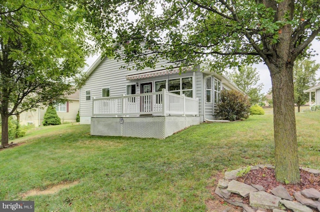 view of front facade featuring a front lawn and a wooden deck