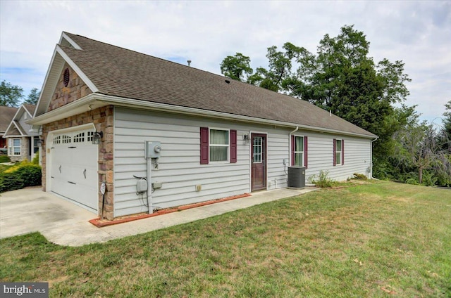 view of home's exterior featuring a lawn, central air condition unit, and a garage