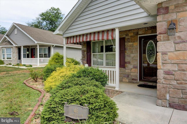 view of exterior entry featuring a lawn