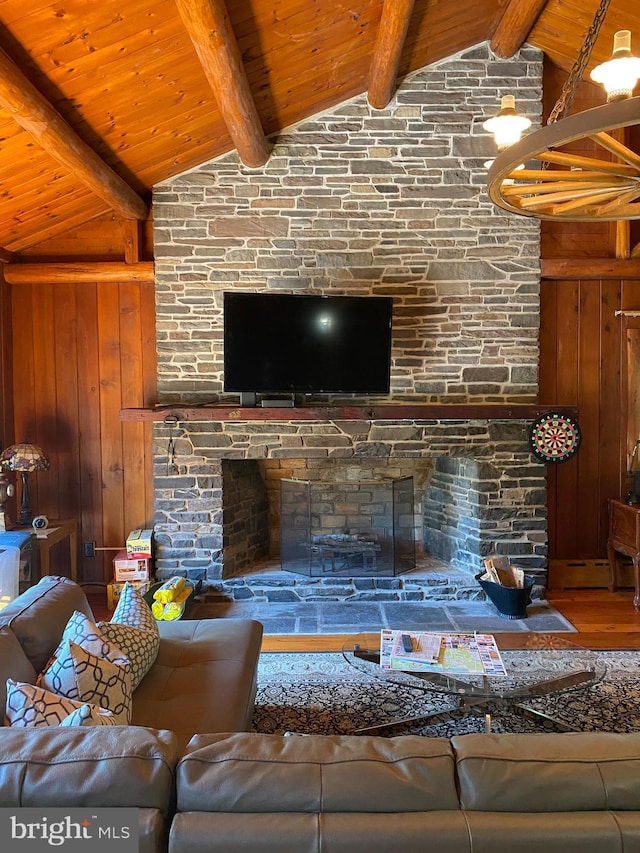 living room featuring wood ceiling, wooden walls, beamed ceiling, hardwood / wood-style floors, and a stone fireplace