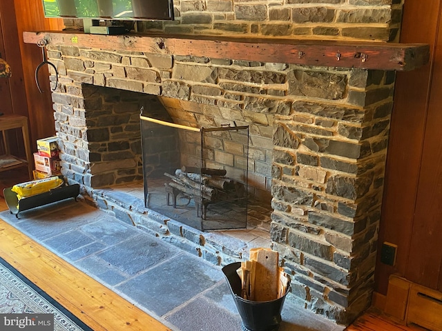 interior details with a stone fireplace and wood-type flooring