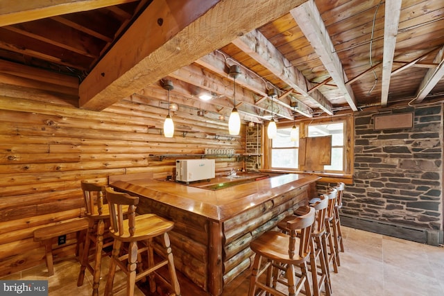 bar featuring beam ceiling, log walls, wooden ceiling, wood counters, and pendant lighting