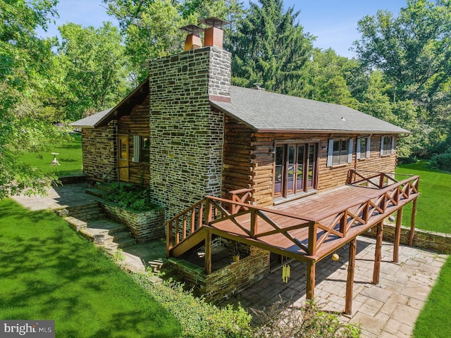 back of house featuring a lawn, a patio area, and a wooden deck