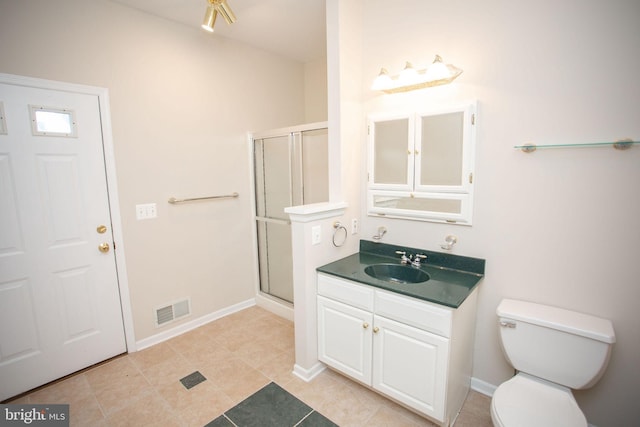 bathroom with tile patterned floors, vanity, an enclosed shower, and toilet