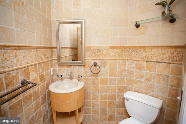 bathroom featuring sink, toilet, and tile walls