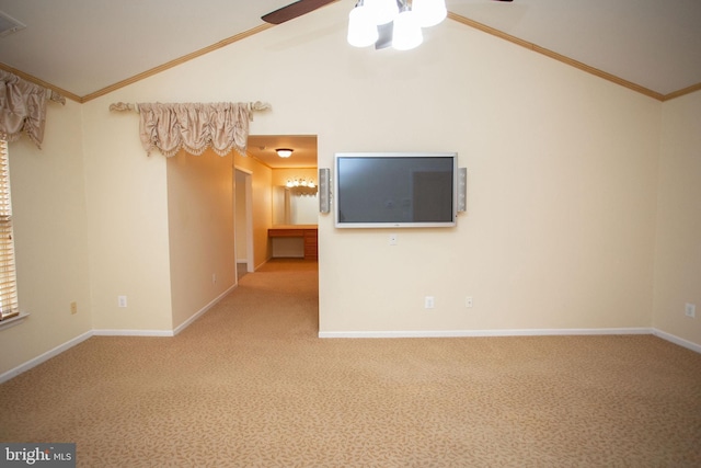 carpeted spare room featuring ceiling fan, ornamental molding, and lofted ceiling