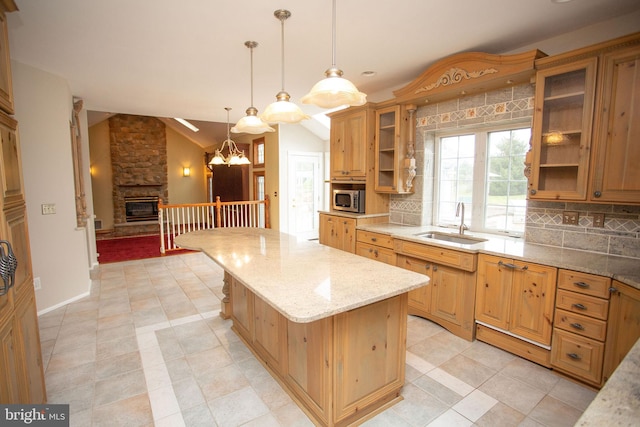 kitchen featuring decorative light fixtures, a kitchen island, sink, and tasteful backsplash