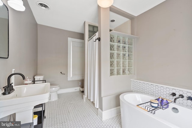 bathroom with a bathtub, toilet, and sink