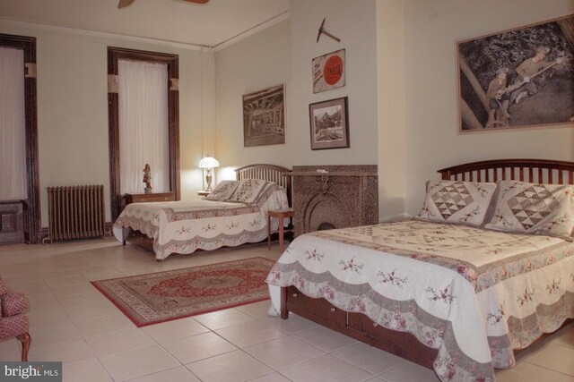 tiled bedroom featuring ceiling fan, radiator heating unit, and crown molding