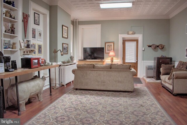 living room with ornamental molding and light hardwood / wood-style flooring