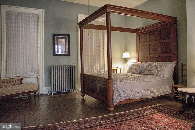 bedroom with radiator heating unit and hardwood / wood-style floors