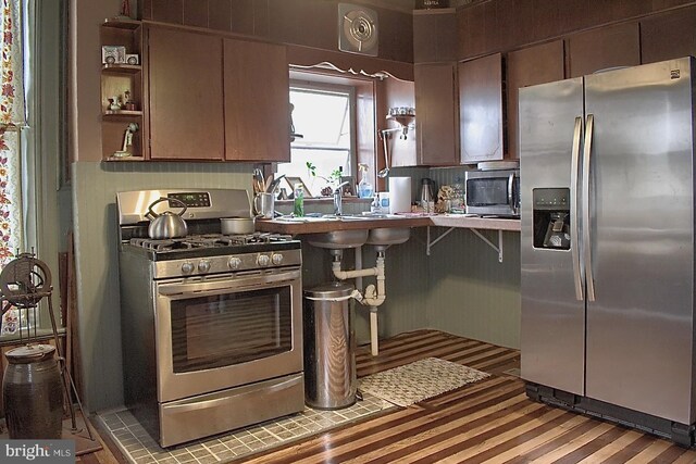 kitchen featuring appliances with stainless steel finishes, a kitchen breakfast bar, and sink