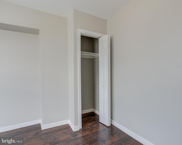 unfurnished bedroom with a closet and dark hardwood / wood-style floors