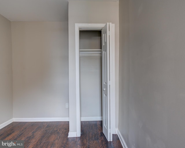 unfurnished bedroom featuring a closet and dark wood-type flooring