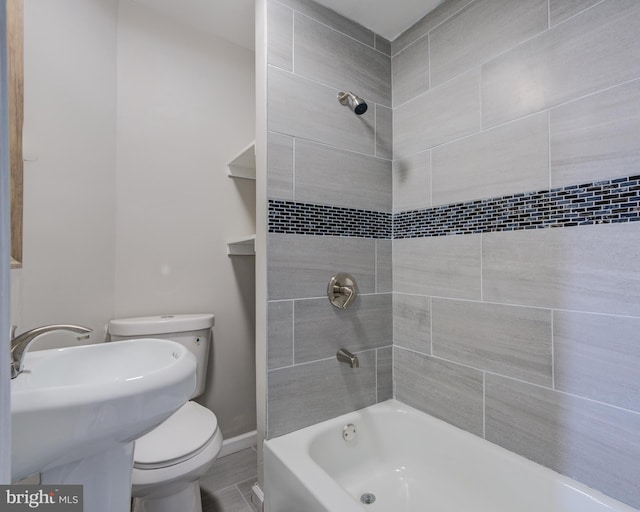 bathroom featuring toilet and tiled shower / bath combo