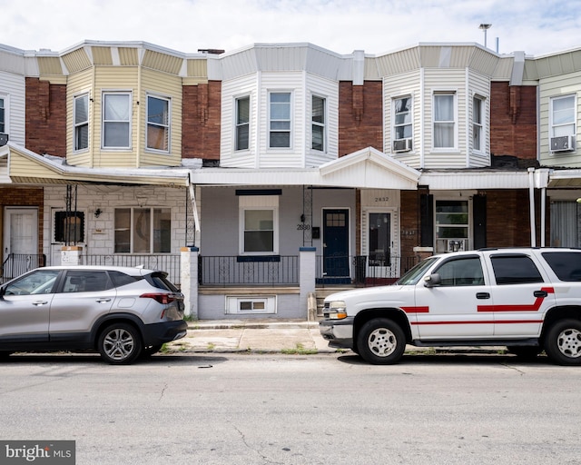 townhome / multi-family property with a porch and cooling unit