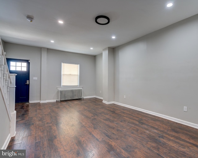 interior space with a healthy amount of sunlight, radiator heating unit, and dark hardwood / wood-style flooring