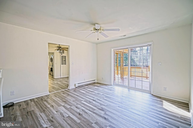 unfurnished room with light hardwood / wood-style floors, a baseboard radiator, stacked washer / dryer, and ceiling fan