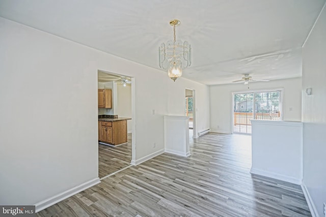 unfurnished room with a baseboard heating unit, light hardwood / wood-style flooring, and a notable chandelier