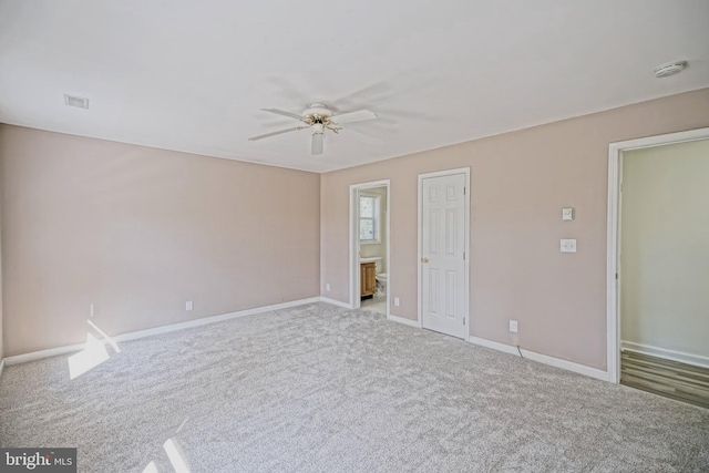 unfurnished bedroom featuring ceiling fan, light carpet, and ensuite bathroom