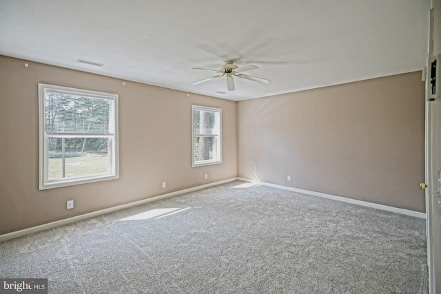 carpeted spare room with ceiling fan and a healthy amount of sunlight