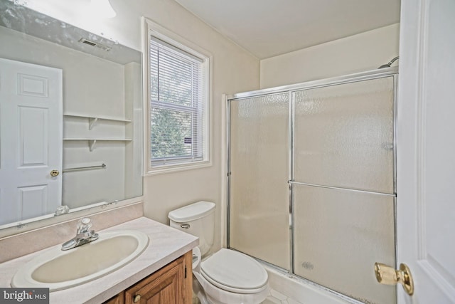 bathroom featuring vanity, toilet, and an enclosed shower