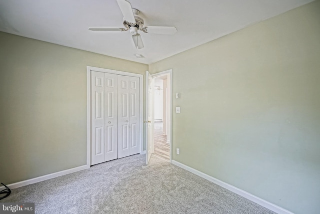 unfurnished bedroom featuring ceiling fan, a closet, and carpet flooring