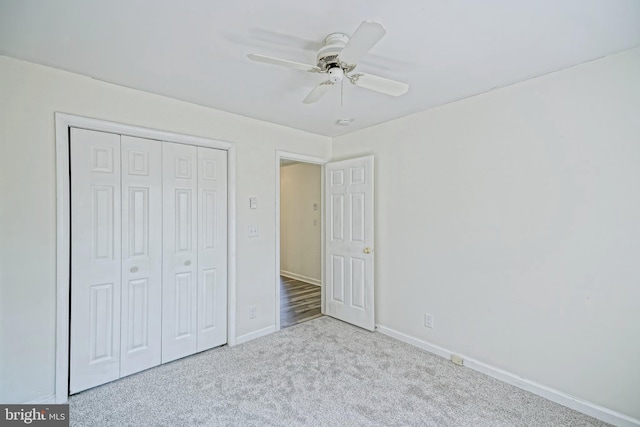 unfurnished bedroom featuring light carpet, ceiling fan, and a closet